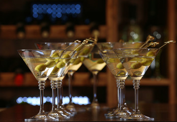 Glasses of cocktails on bar background