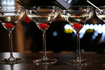 Glasses of cocktails on bar background