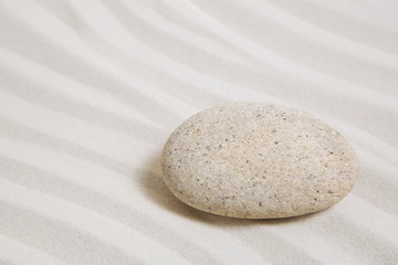 Fototapeta na wymiar Ein Stein als Konzept oder Symbol als Sand Hintergrund