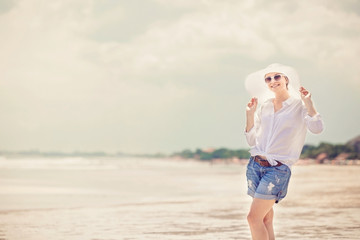 Fototapeta na wymiar Beautifil young woman walking along the beach at sunny day