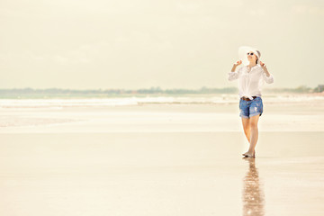 Fototapeta na wymiar Beautifil young woman walking along the beach at sunny day