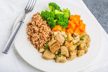 Buckwheat with meat and vegetables ona white plate