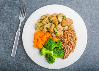 Buckwheat with meat and vegetables ona white plate