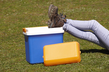 Picnic cooler in the grass and trekking boots in Spain