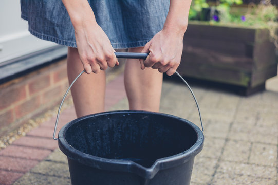 Woman lifting bucket in garden