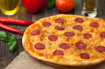 Traditional pizza pepperoni with mozzarella and salami on vintag