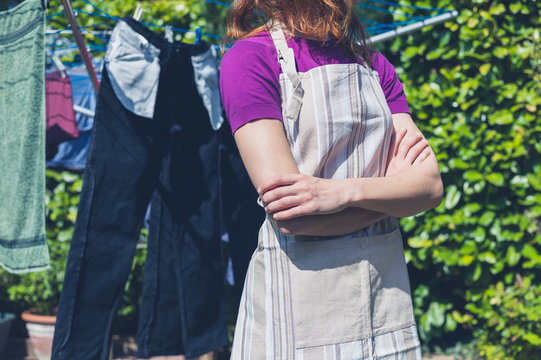 Woman in apron standing by clothes line