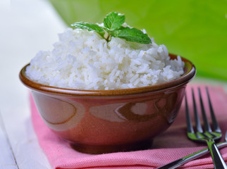 Cooked white rice garnished with mint in a ceramic bowl