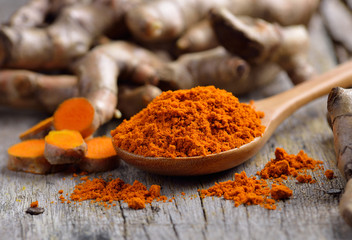 pile of fresh turmeric roots on wooden table - obrazy, fototapety, plakaty