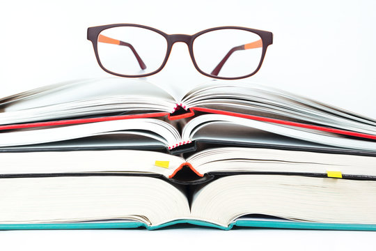 Glasses on stack of open books