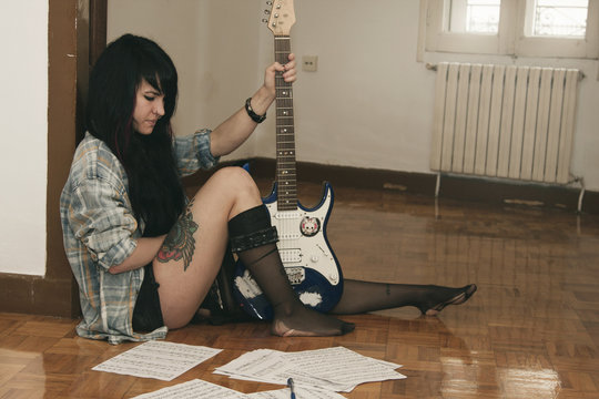 girl playing guitar indoors, lifestyle