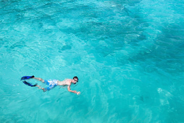 snorkeling, top view of man swimming with fins and mask, copy space