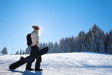silhouette of woman with snowboard on the ski slope