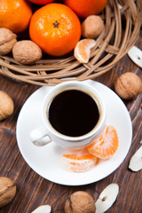 Cup of coffee with tangerines and walnut