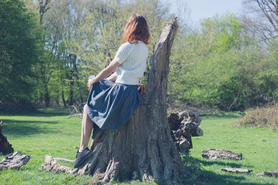 Woman sitting on a tree trunk in the forest