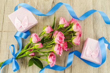 Rose flower and gift box on wooden background