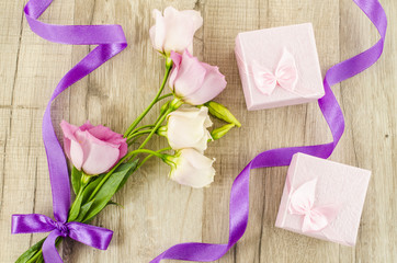 Pink flower and gift box on wooden background