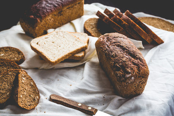 Assorted bread, slices of rye bread on linen tablecloths, wooden