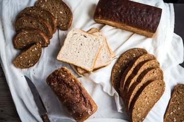 Assorted bread, slices of rye bread on linen tablecloths, wooden
