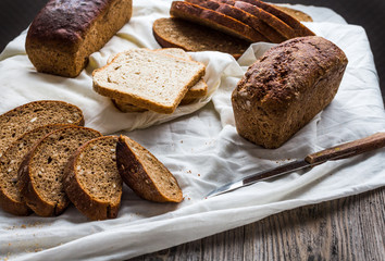 Assorted bread, slices of rye bread on linen tablecloths, wooden