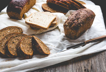 Assorted bread, slices of rye bread on linen tablecloths, wooden