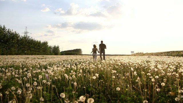 Happy boy and gerl running across the field
