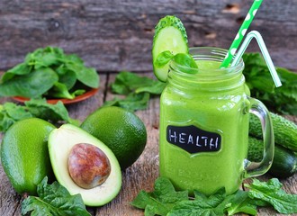 Green vegetable smoothie isolated on wood background © chudo2307