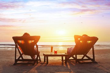 happy couple enjoy luxury sunset on the beach during summer vacations - obrazy, fototapety, plakaty