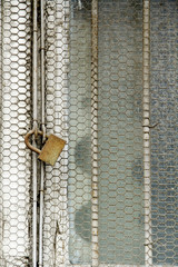Fototapeta na wymiar Rusty metal net and rusty padlock 11