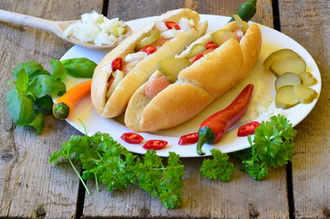 Hot dog with chilli on white plate with wood background
