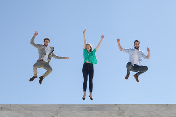 Fototapeta na wymiar Three friends jump on top of a staircase