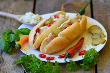 Hot dog with chilli on white plate with wood background
