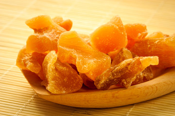 Closeup candied ginger on wooden spoon