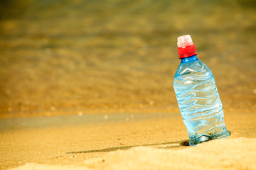 bevarage. bottle of water drink on a sandy beach.