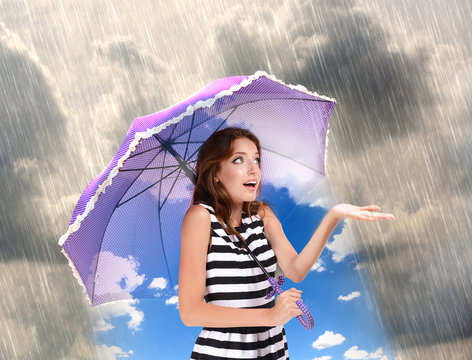 Girl with umbrella standing under the rain