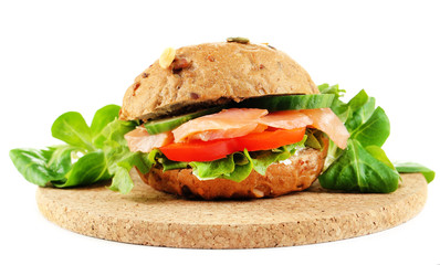 Sandwich with salmon on wooden board isolated on white