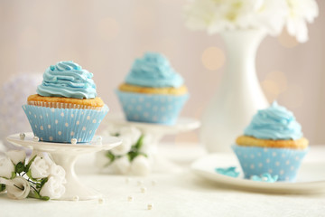 Delicious cupcakes on table on light background