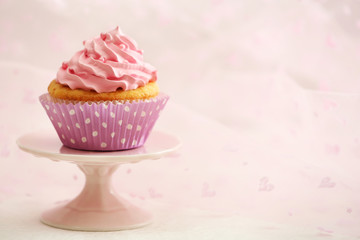 Sweet cupcake on table on light background