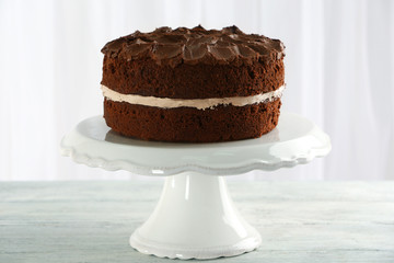 Delicious chocolate cake on table on light background