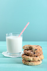 Tasty cookies and glass of milk on color wooden background