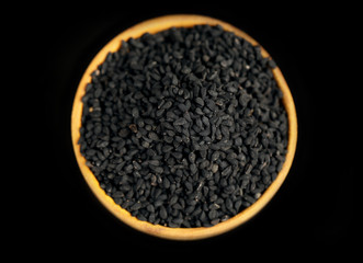 Black sesame in wooden bowl, isolated on black