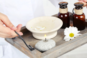 Beauty therapist holding tray of spa treatments, close-up