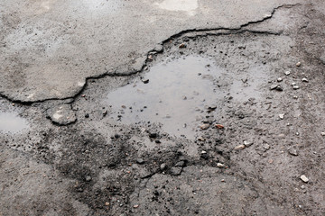 Very bad quality road with potholes and puddles