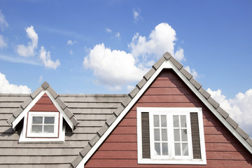 Fototapeta na wymiar Brown tile roof in garden against blue sky.