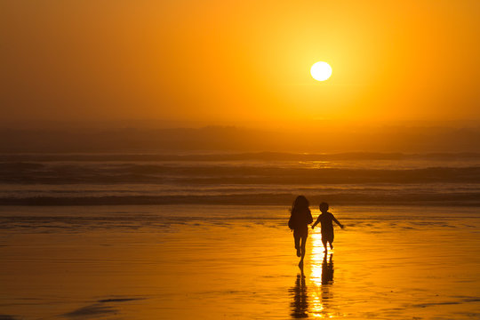 Kids running on beach silhouette