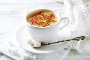 Cup of latte on wooden table, on light background