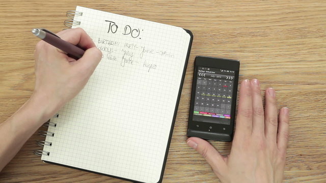 Woman planning "To do" list with smartphone calendar