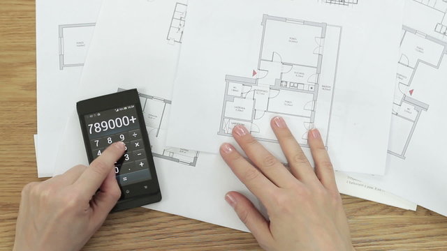 Woman working with calculator and blueprint, top view