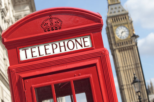 London red telephone box booth with westminster british houses of parliament building and Big Ben clock tower in the background photo