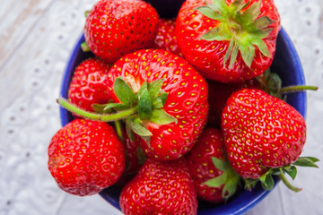 Fresh strawberries in a small blue bowl